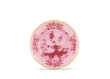 Pink decorative plate with intricate patterns on a white background