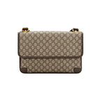 A Gucci shoulder bag in beige and brown GG Supreme canvas with dark brown leather trim and gold-tone hardware, shown against a plain white background.