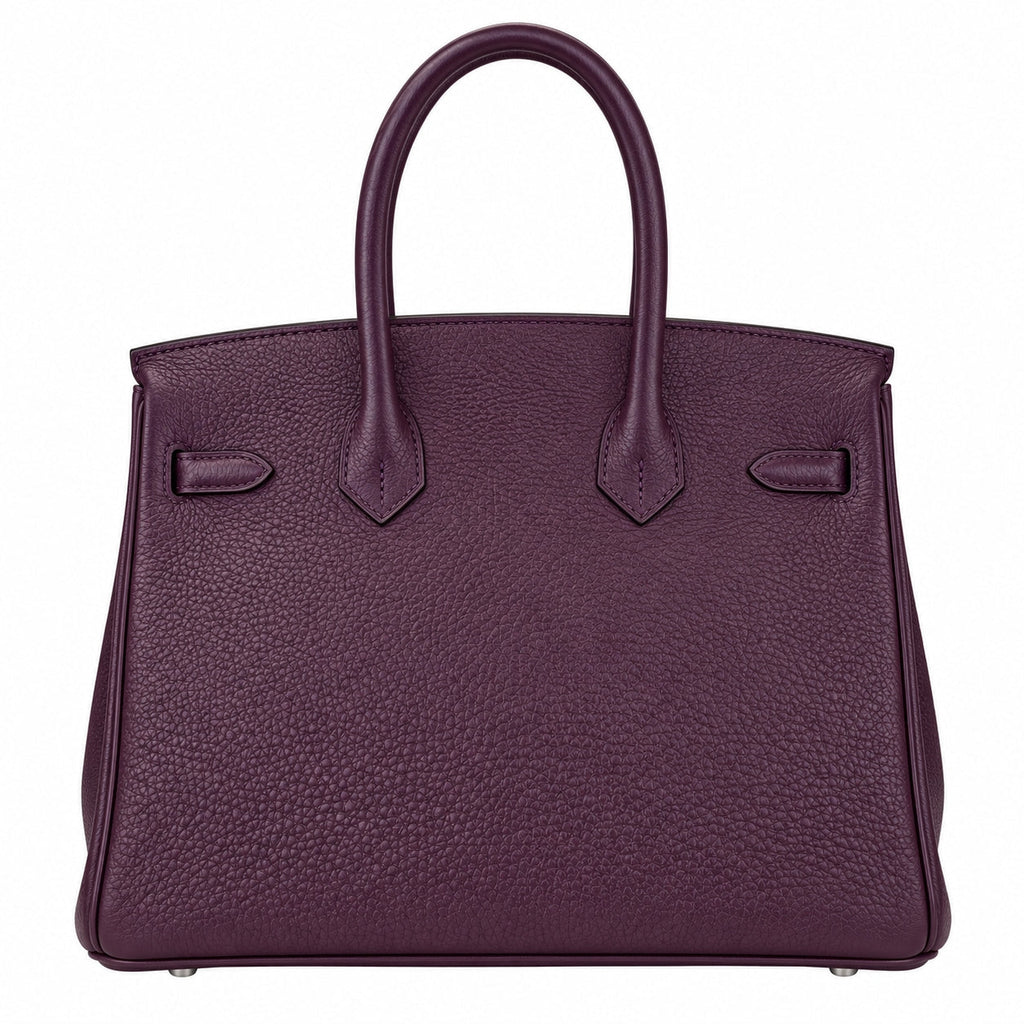 A dark purple pebbled leather handbag with double top handles, shown against a plain white background.
