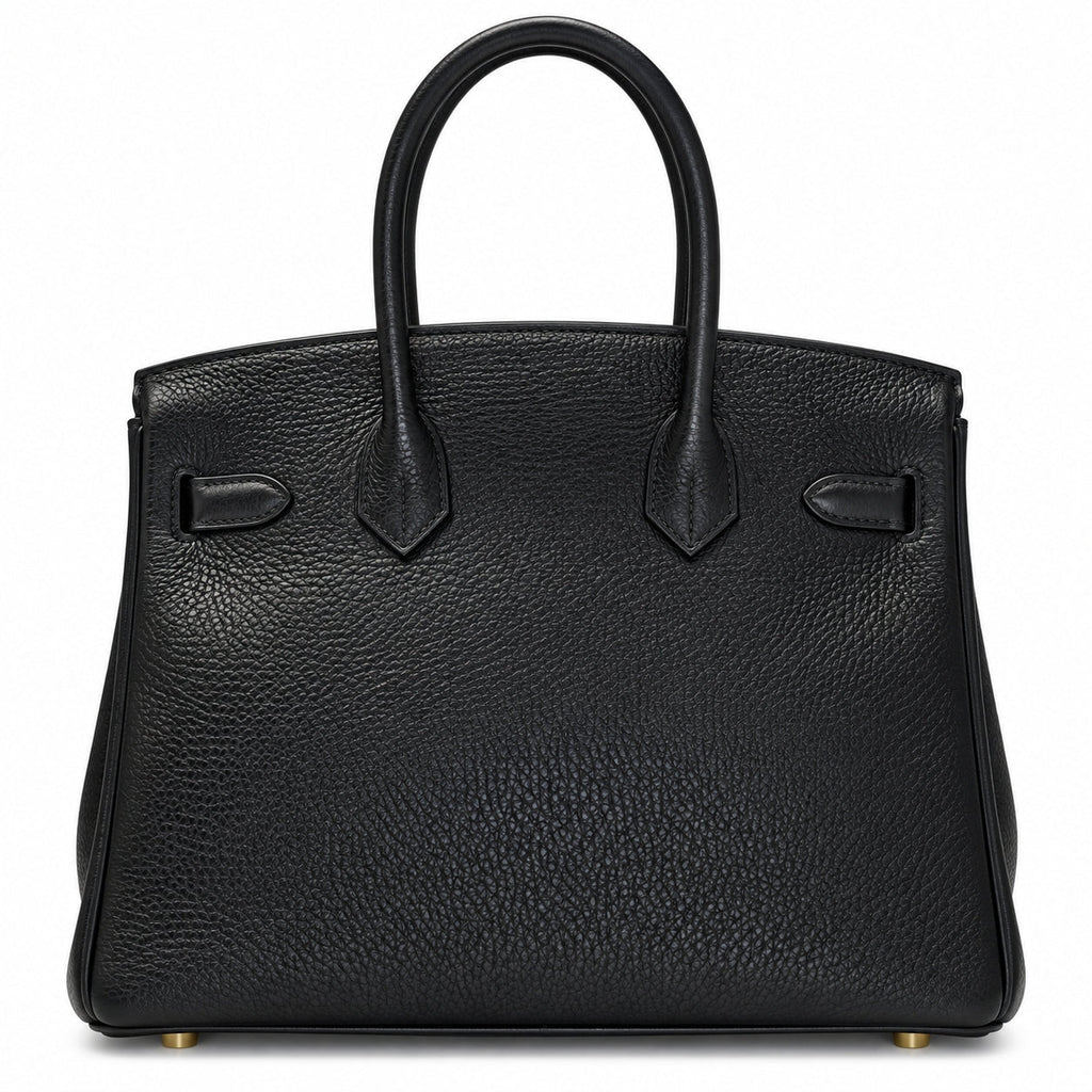 A black pebbled leather handbag with double top handles, structured silhouette, and gold-tone hardware, photographed against a plain white background.