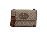 Gucci shoulder bag in beige GG Supreme canvas with brown leather trim, a green and red web stripe detail, and a gold-tone logo plaque on the front flap.