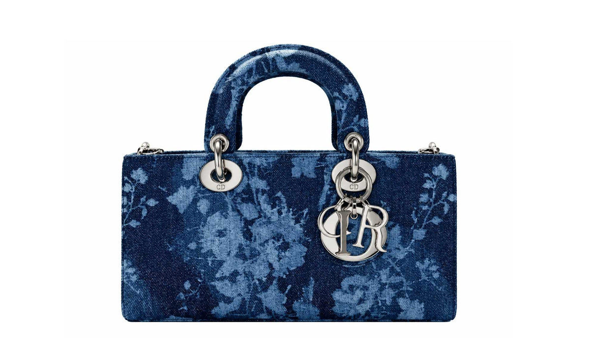 A blue floral patterned Christian Dior Lady Dior handbag with silver-tone hardware and a signature CD charm, shown against a plain white background.