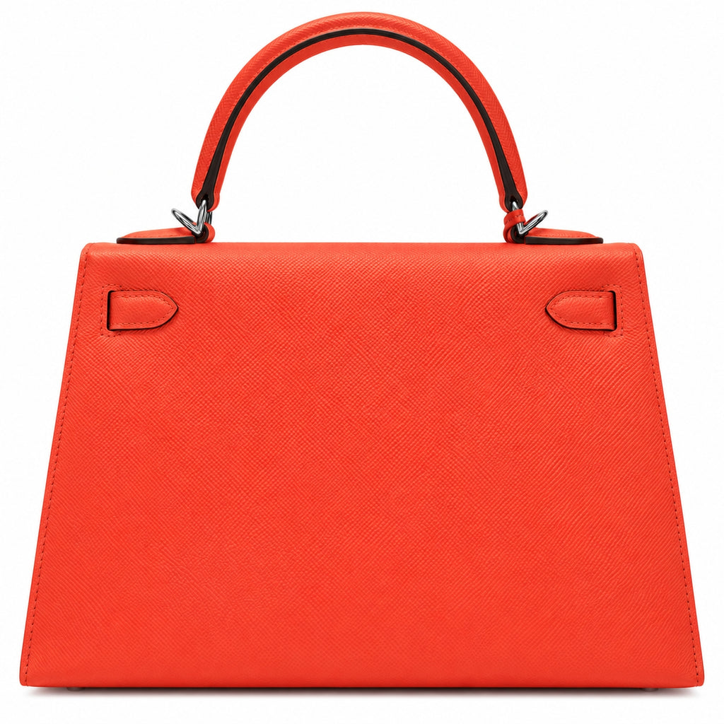 A structured top-handle handbag in bright orange-red textured leather with silver-tone hardware, shown against a plain white background.