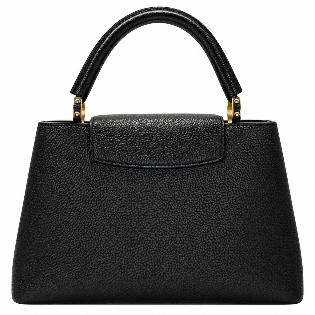 A black pebbled leather handbag with a structured shape, top handle, and gold-tone hardware, shown against a plain white background.