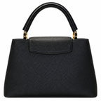 A black pebbled leather handbag with a structured shape, top handle, and gold-tone hardware, shown against a plain white background.
