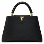 A black pebbled leather handbag with a structured silhouette, dual top handles, and a gold-tone Louis Vuitton monogram logo on the front, set against a plain white background.