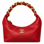 A red quilted leather shoulder bag with a gold-tone interlocking CC logo on the front and a braided chain handle, shown on a plain white background.