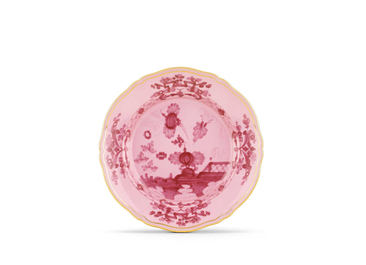Pink decorative plate with intricate patterns on a white background